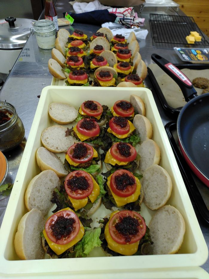 constructed burgers in various containers with the tops off to show the layers