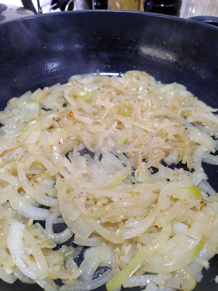 some onions caramelising in a black pan