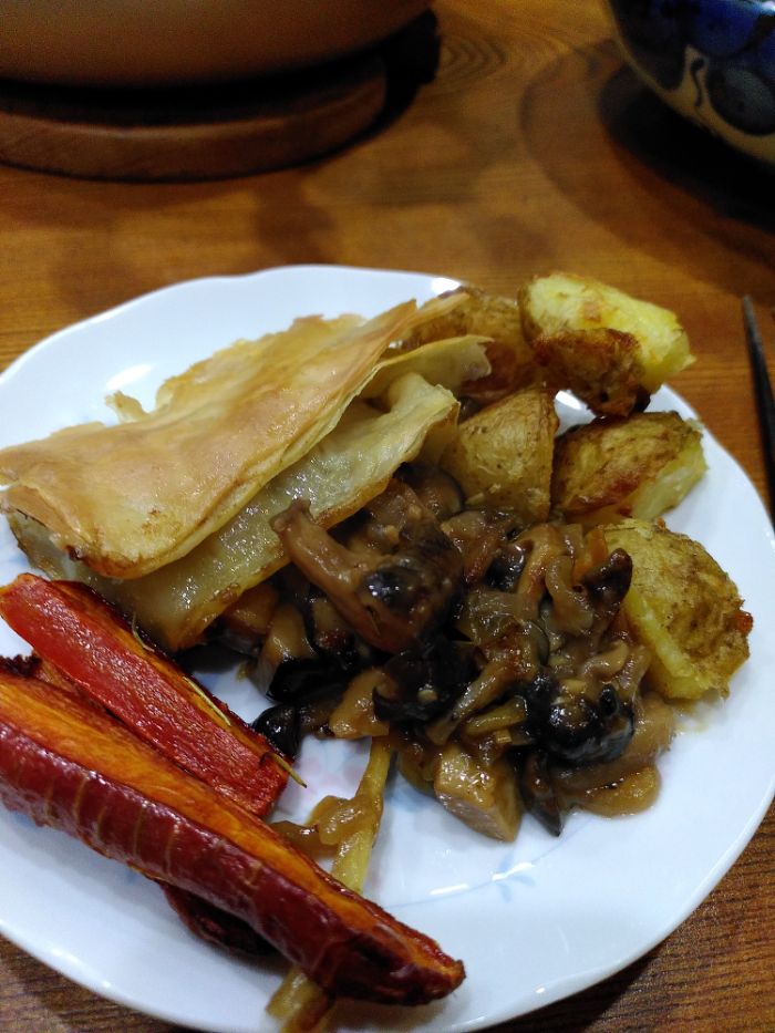 a white plate with some pie and roasted veggies.