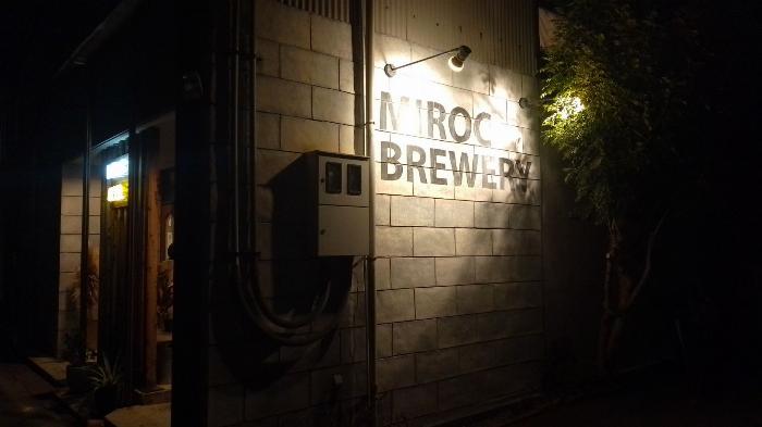 night shot of an industrial wall with the Miroc Beer sign illuminated