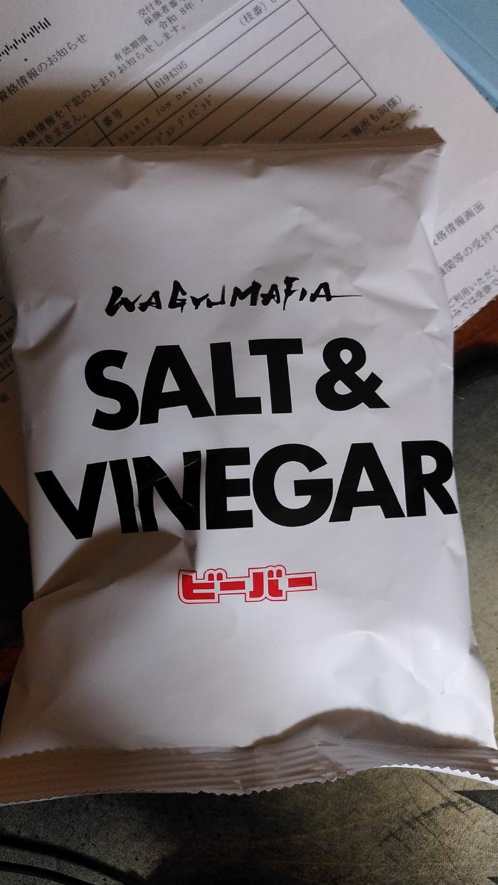 A plain white potato chips packet with black text that reads "Salt and Vinegar"